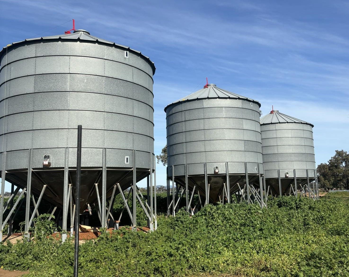A Row of Silos in a Field With a Blue Sky in the Background — Welders In Gilgandra, NSW