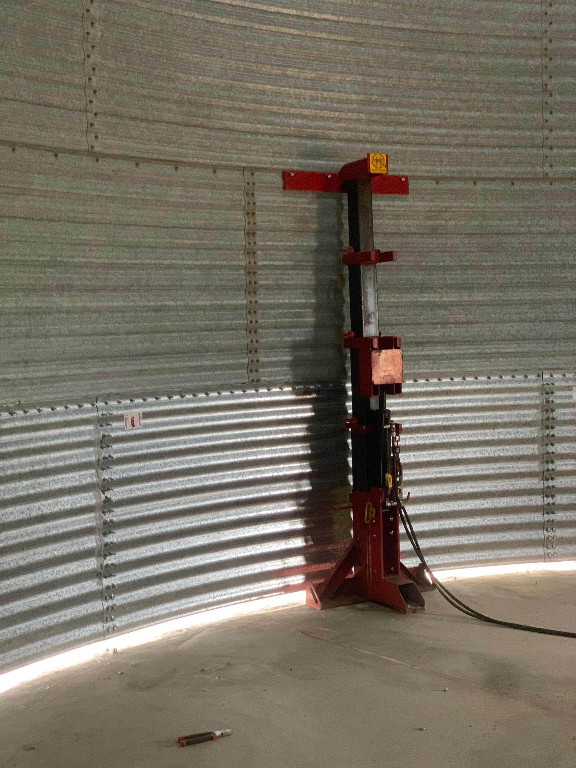 A Metal Silo With a Red Machine in the Middle of It — Welders In Gilgandra, NSW
