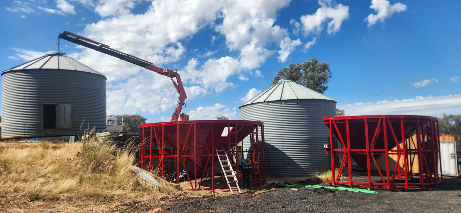 A Crane is Sitting in Front of a Row of Silos — Welders In Gilgandra, NSW