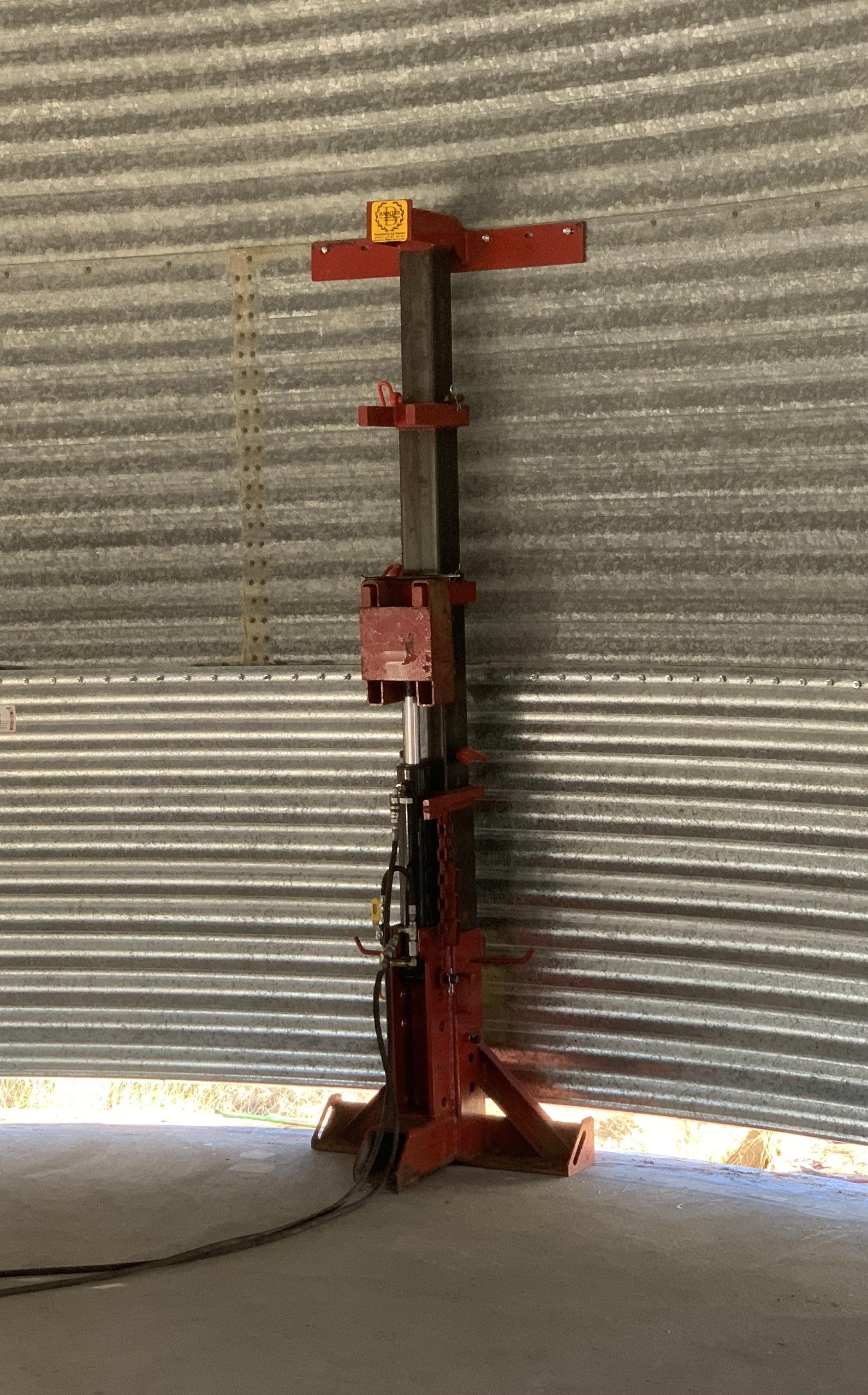 A Red Machine is Sitting in Front of a Metal Wall — Welders In Gilgandra, NSW