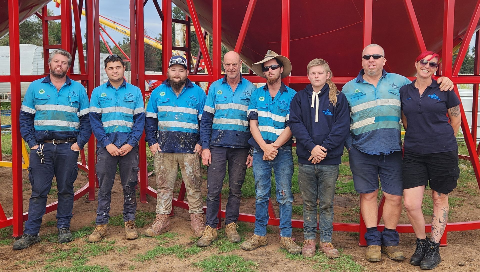 A Group of Construction Workers Are Posing for a Picture in Front of a Red Structure — Welders In Gilgandra, NSW