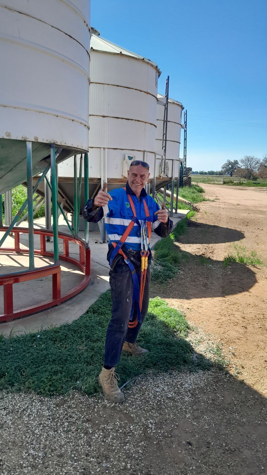 A Man is Standing in Front of a Row of Silos on a Farm — Welders In Gilgandra, NSW