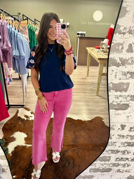 A woman is taking a selfie in front of a mirror in a store.