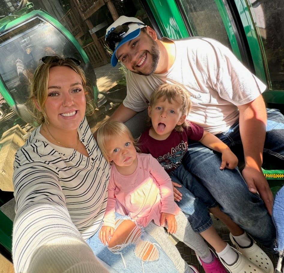 A man and a woman are taking a selfie with two children.