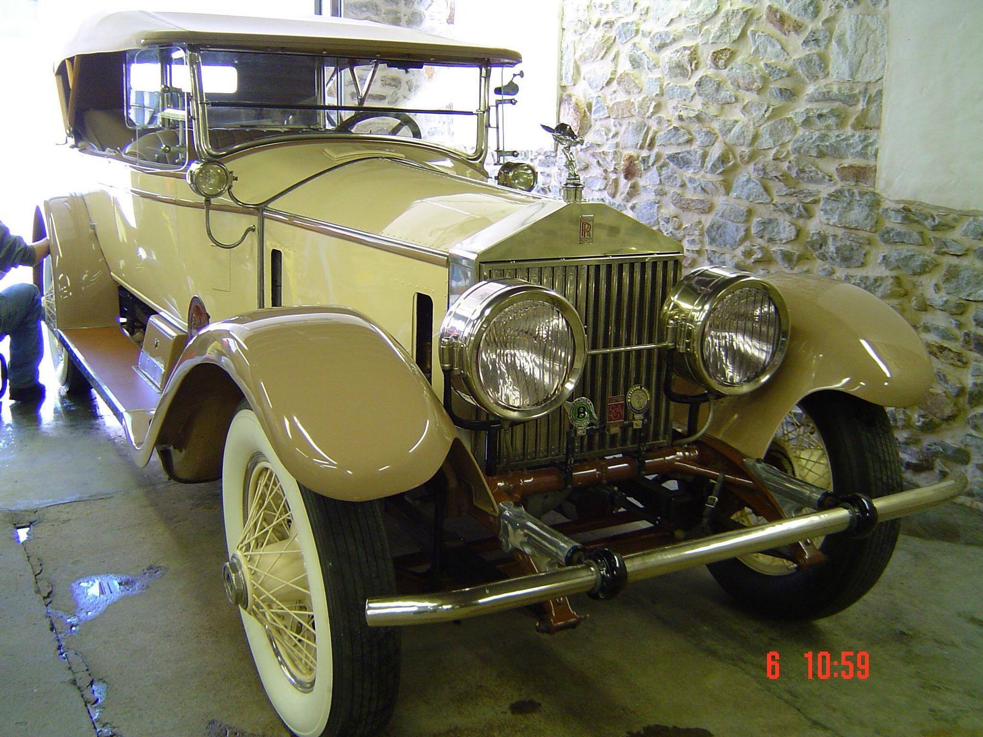 An old rolls royce car is parked in a garage