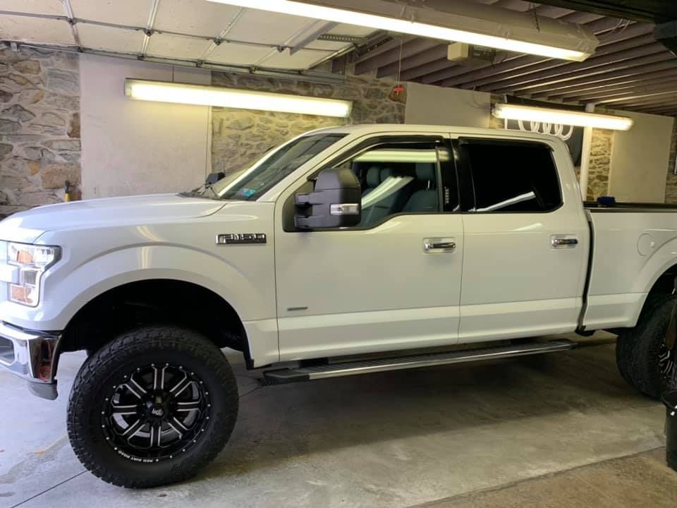 A white pickup truck is parked in a garage.