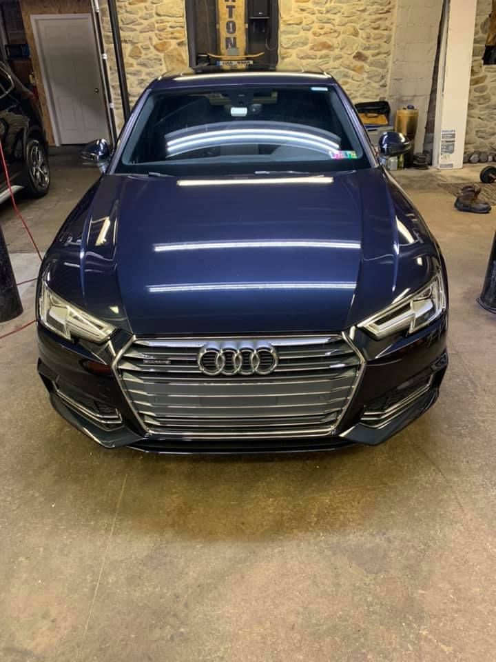 A black audi a4 is parked in a garage.