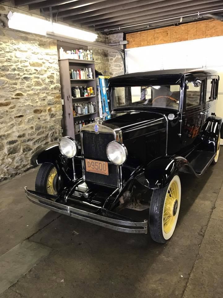 An old black car with a license plate that says 7650