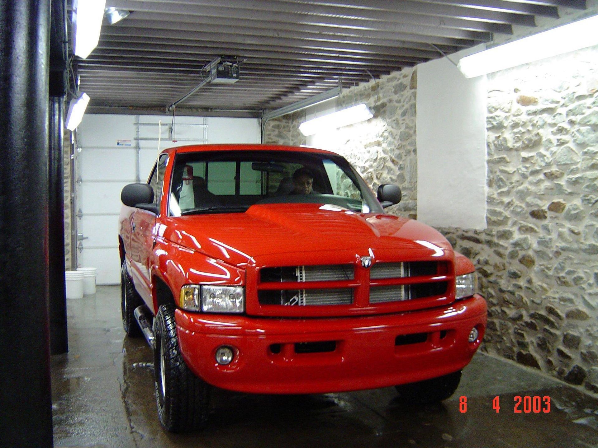 A red dodge ram truck is parked in a garage