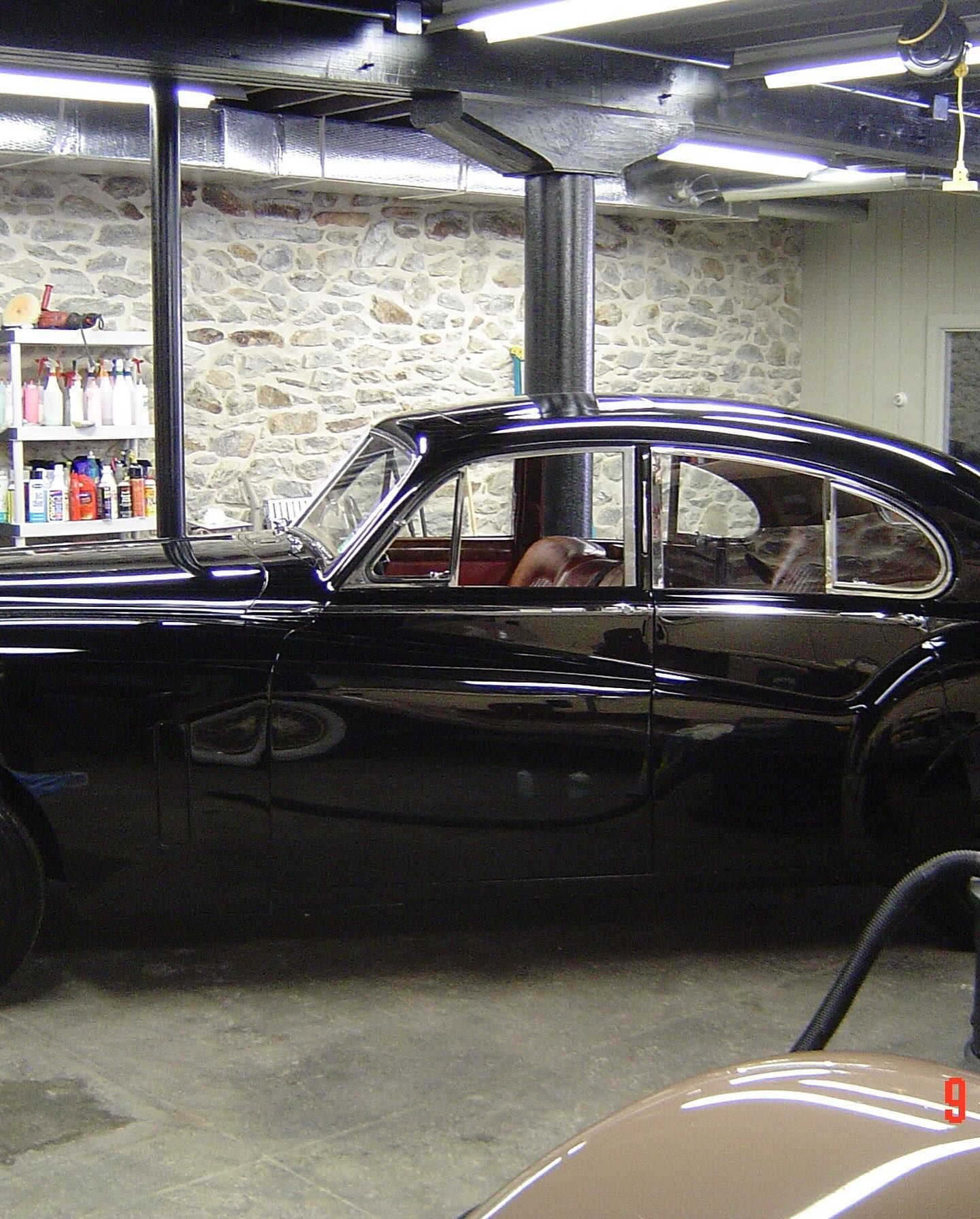 A black car is parked in a garage with the number 9 on the side