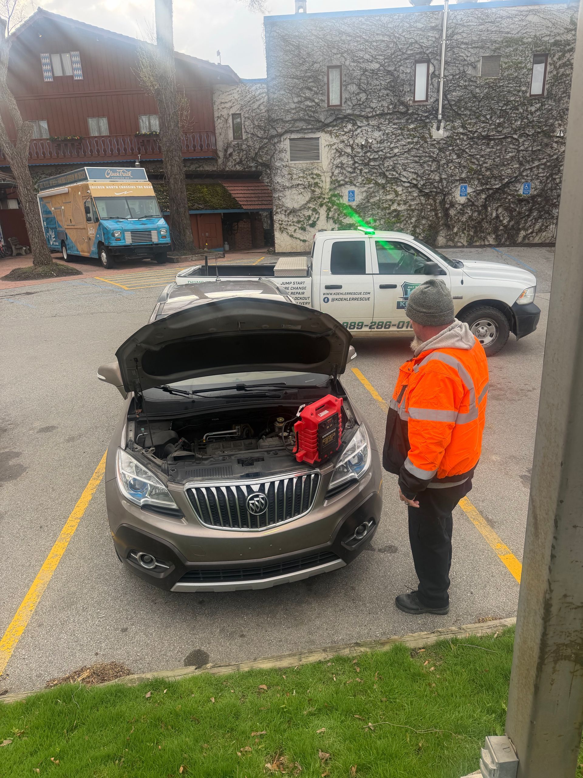 mike jump starting a car for a customer with koehler rescue services vehicle in the background