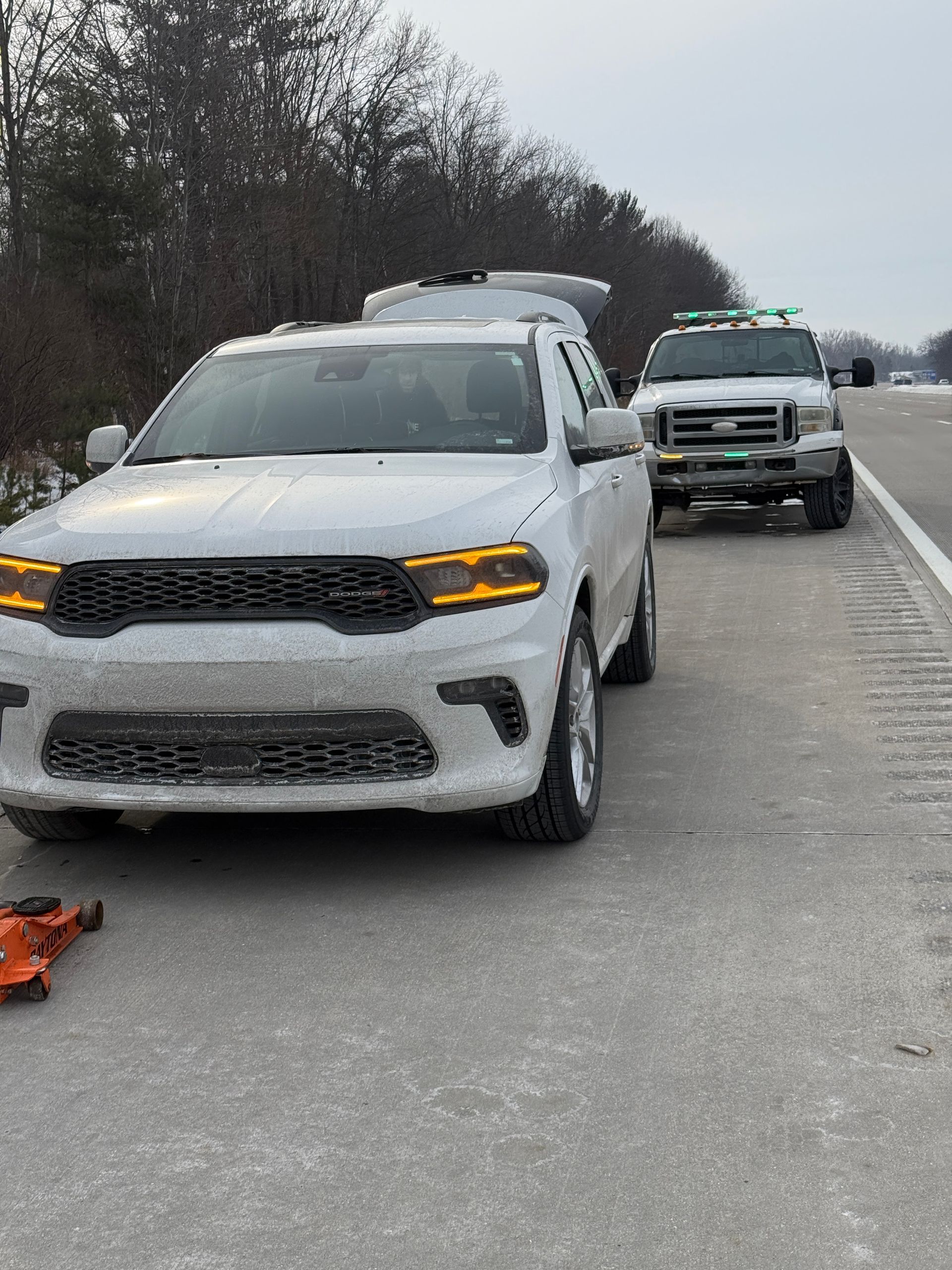 Two white cars are parked on the side of the road.