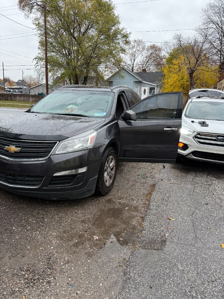 A black car is parked next to a white car in a parking lot.