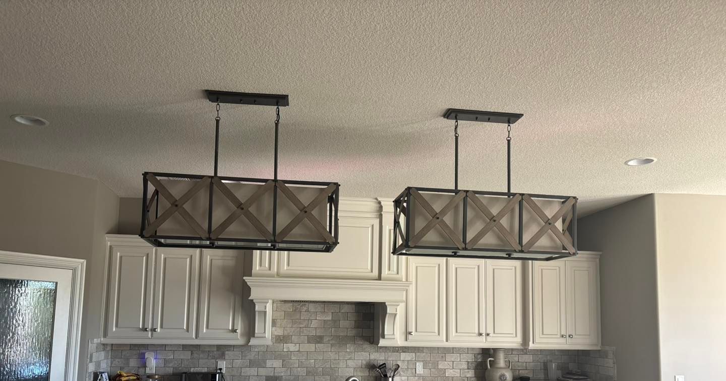 Two rectangular wooden light fixtures hanging above white kitchen cabinets.