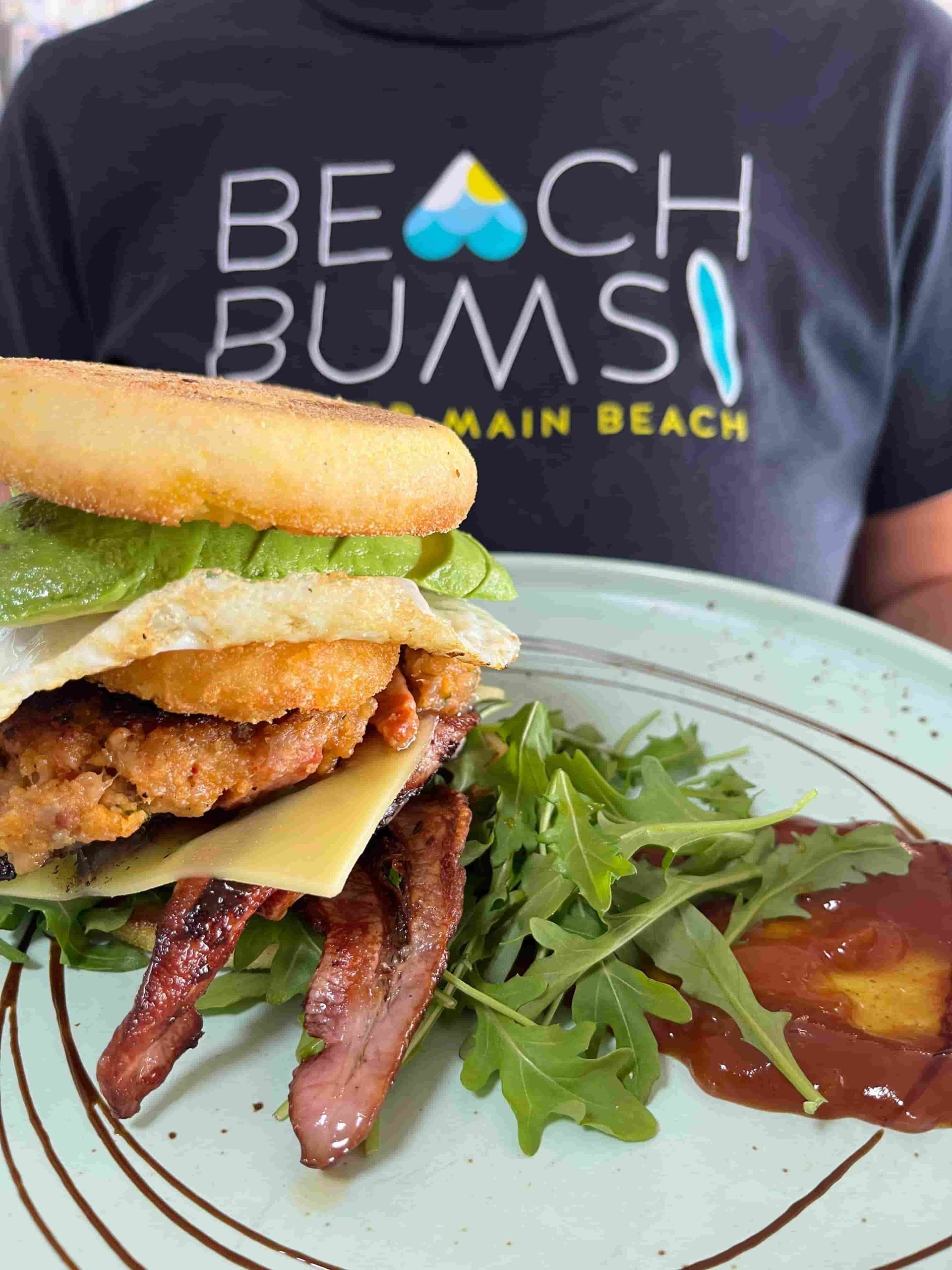 Beach Bums Shirt is Holding a Plate of Food — Beach Bums Cafe In Forster, NSW