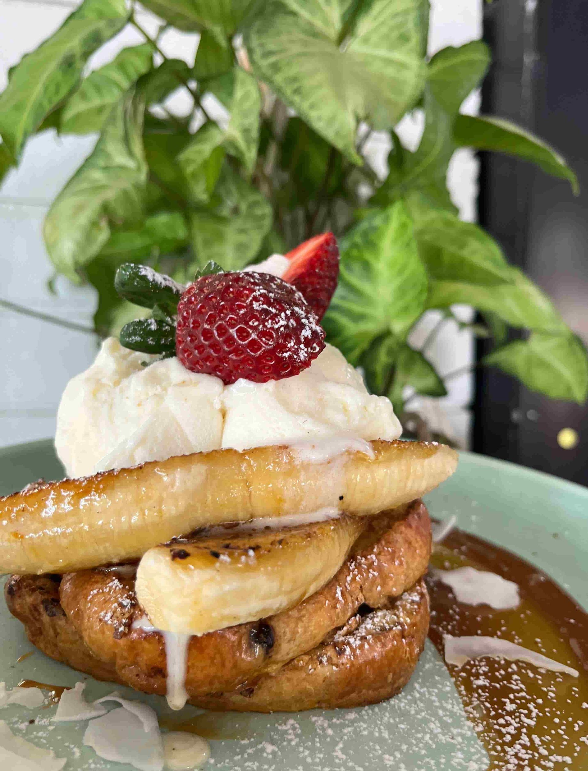 A Stack Of French Toast With Bananas, Whipped Cream And Strawberries On Top — Beach Bums Cafe In Forster, NSW