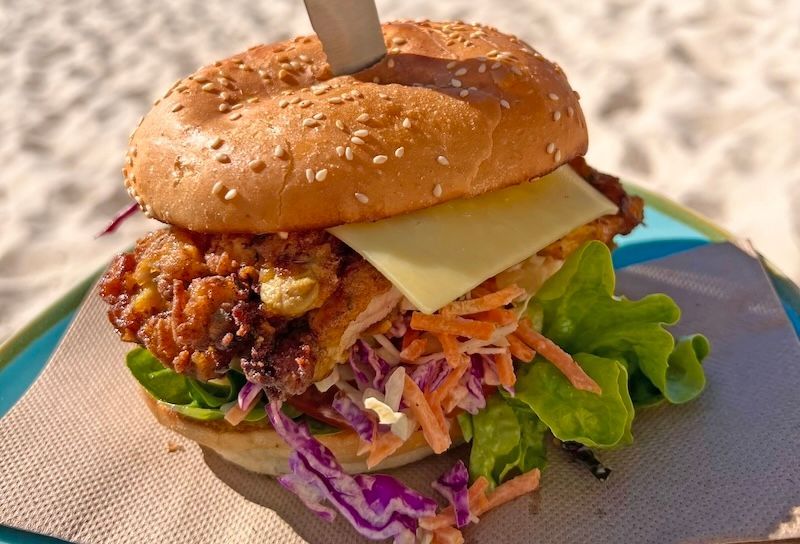 A Plate Of Food With A Chicken Schnitzel Burger on it — Beach Bums Cafe In Forster, NSW