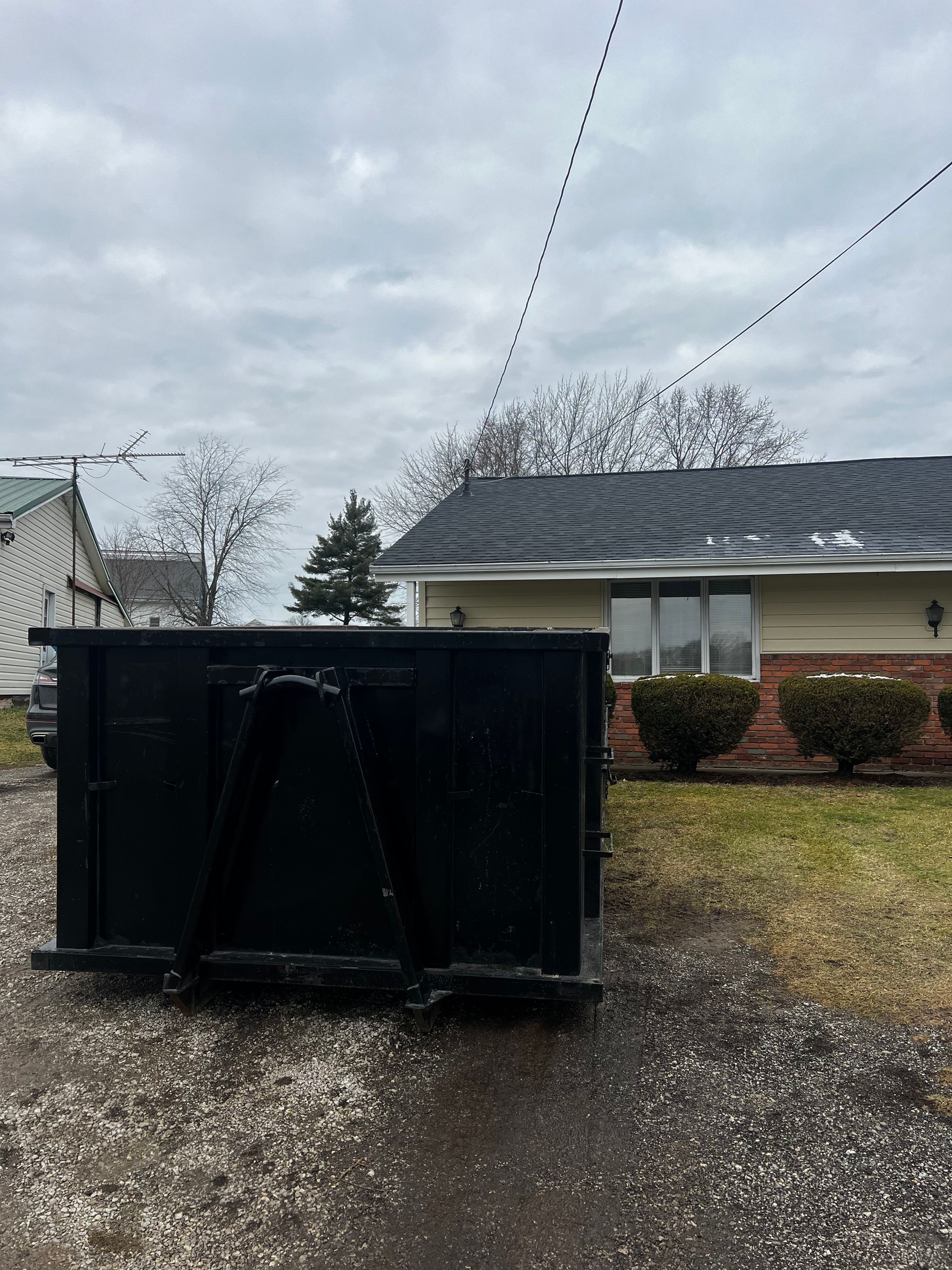 A dumpster is parked in front of a house.