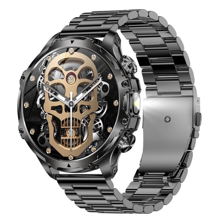 Reloj de pulsera con temática de calavera en color negro y dorado y correa de metal negra.