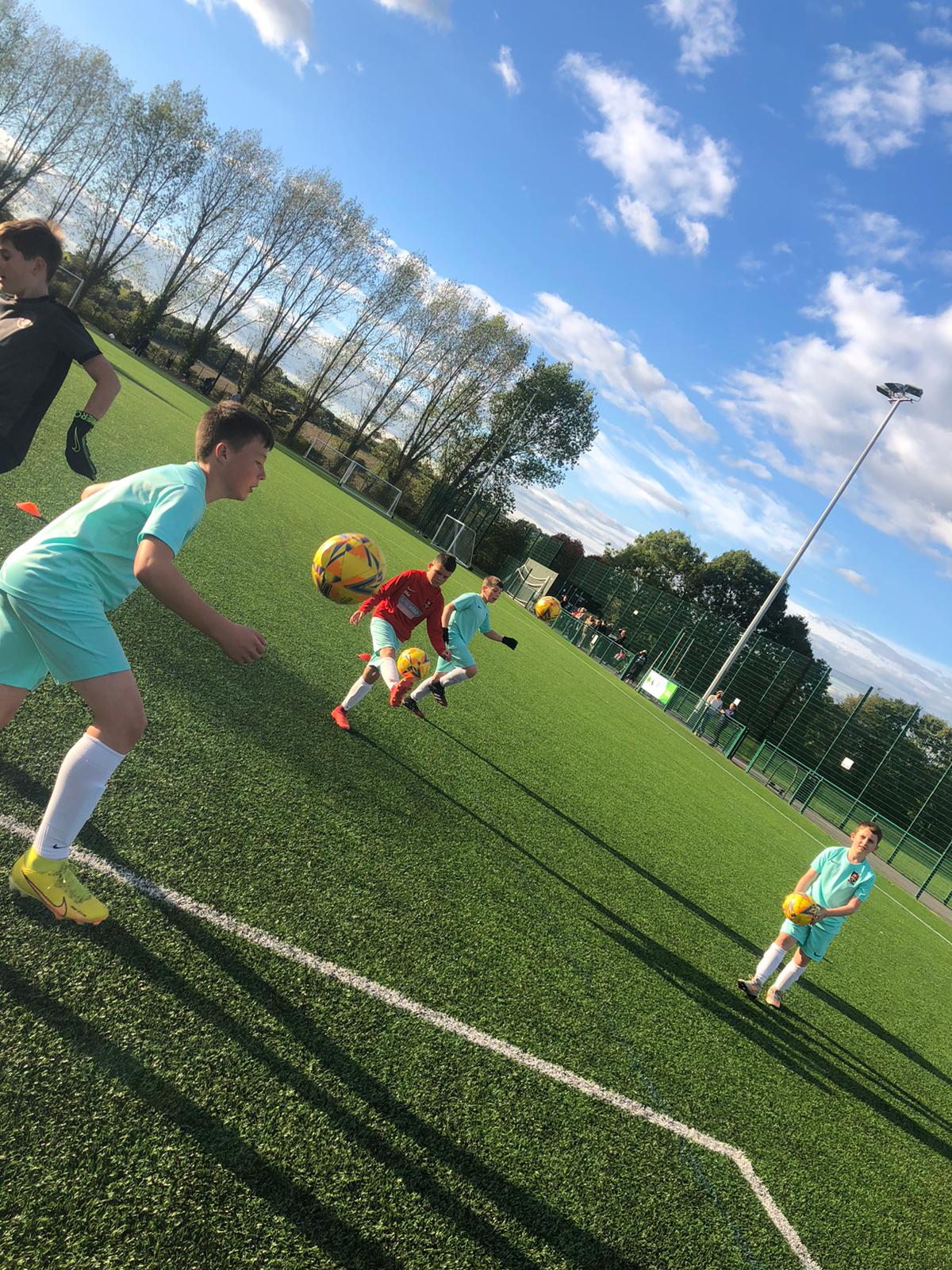 A group of children are playing soccer on a field.