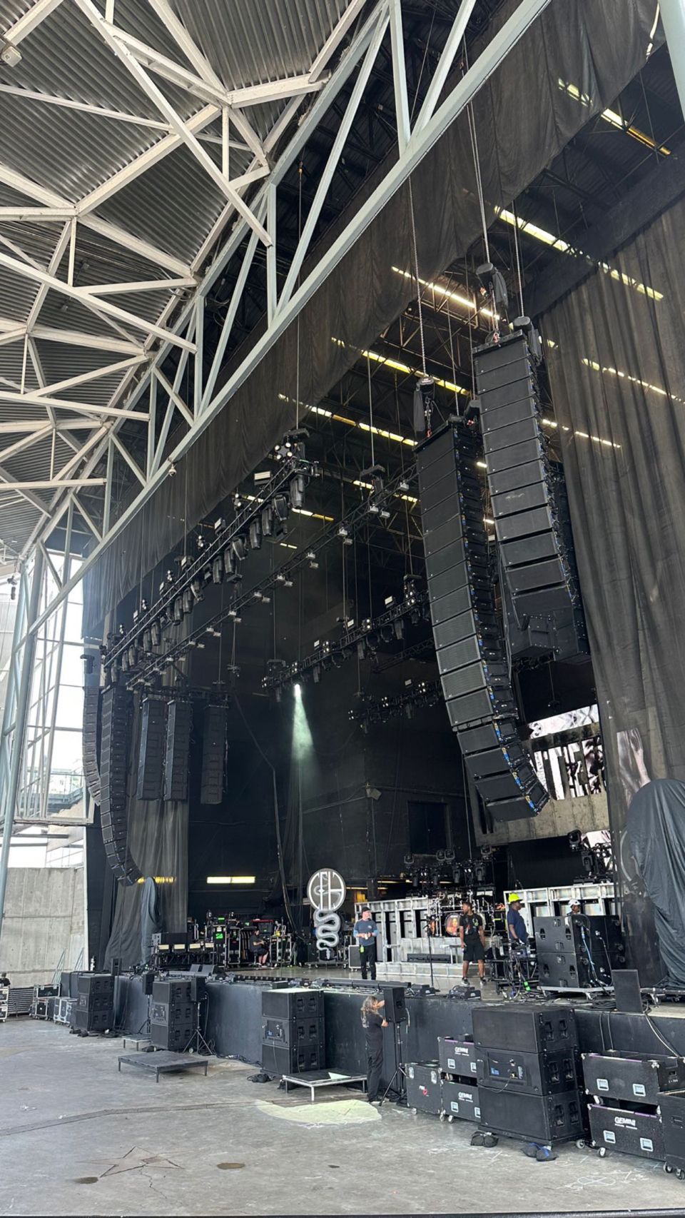 A large stage with a lot of speakers hanging from the ceiling.
