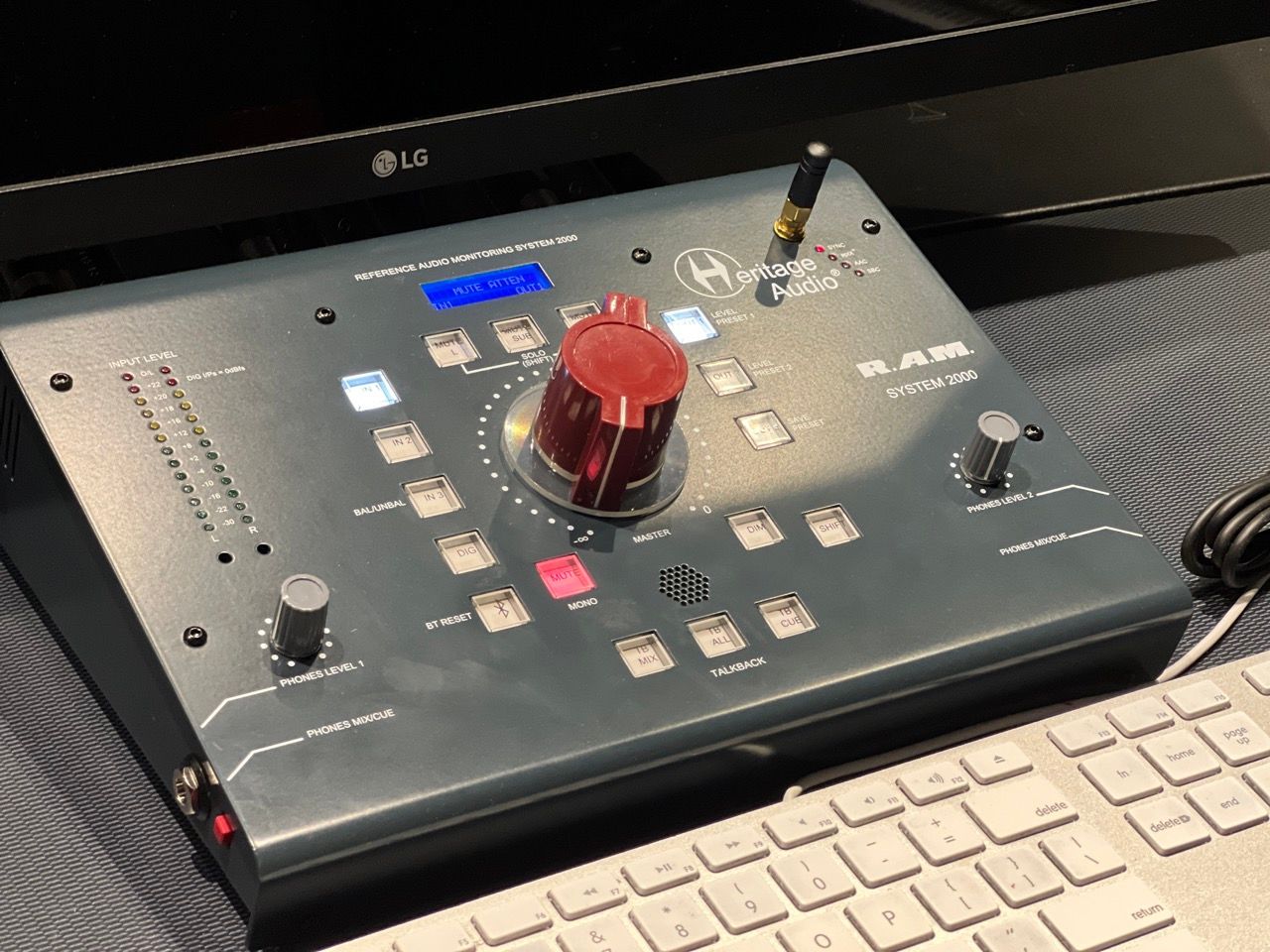 A black box with a red knob is sitting on top of a white keyboard.