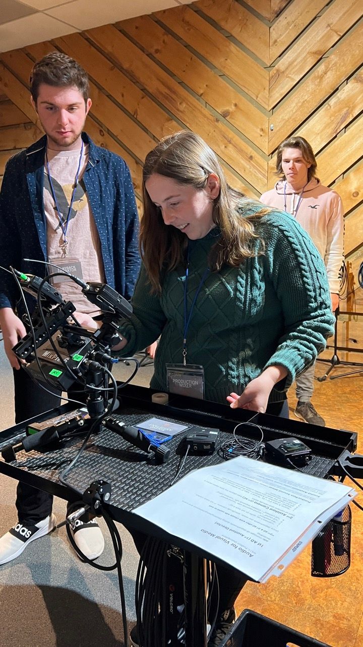 A group of people are working on a camera in a studio.