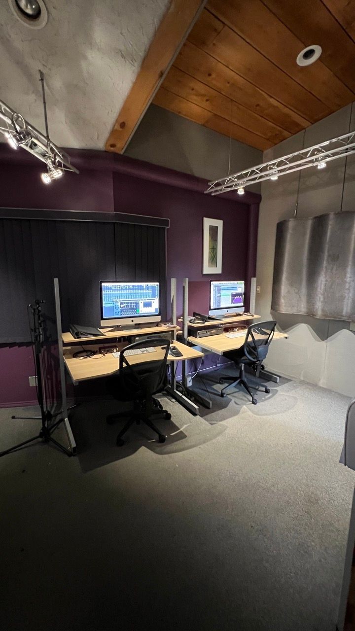 A room with a lot of computers on the desks and chairs.