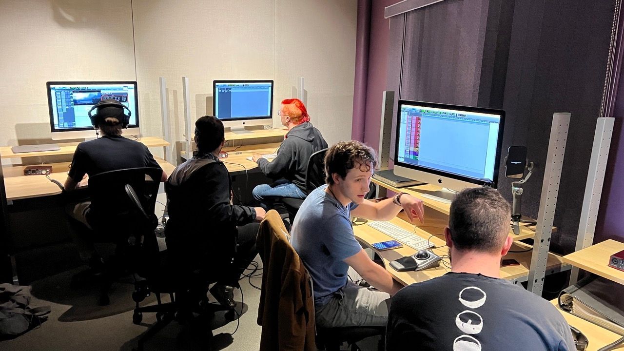 A group of people are working on computers in a room.