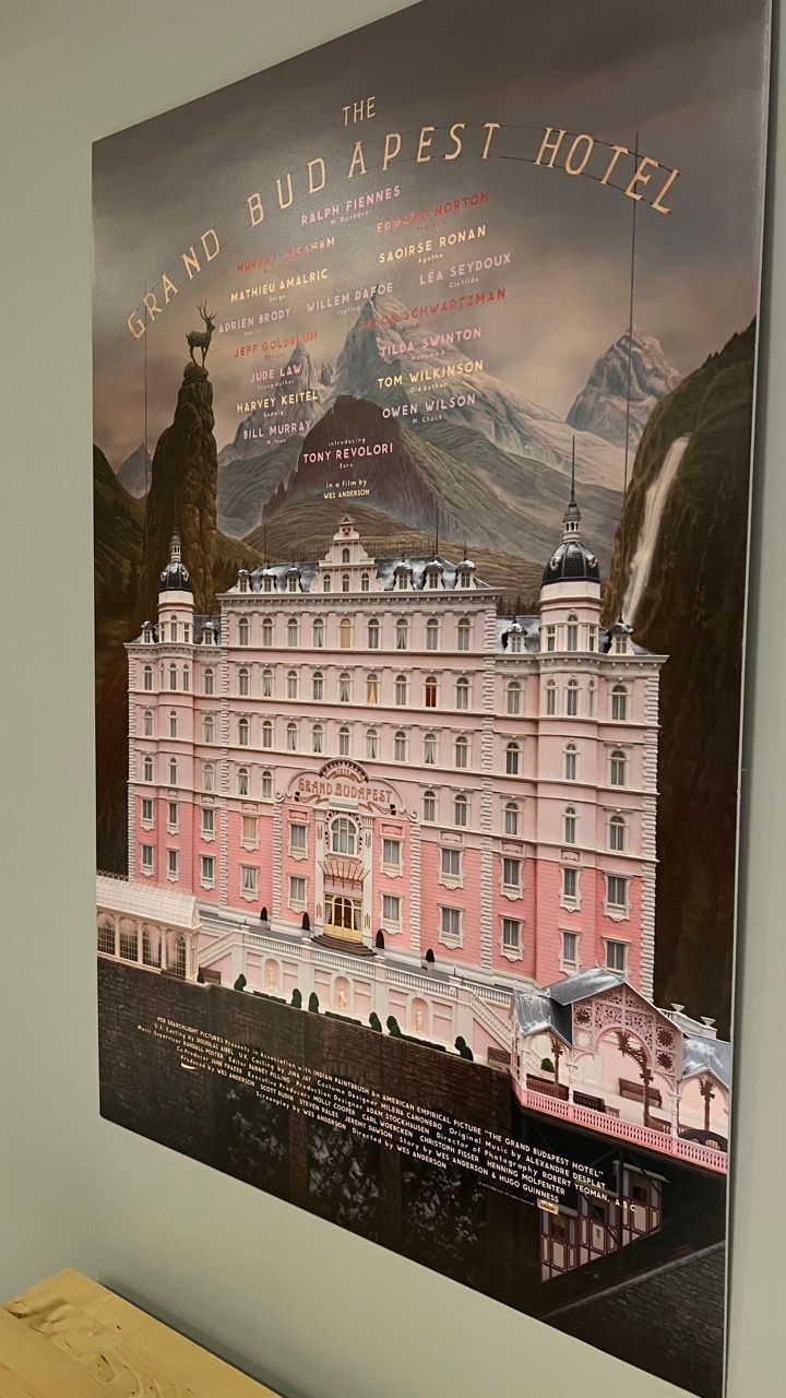 A poster of the budapest hotel is hanging on a wall