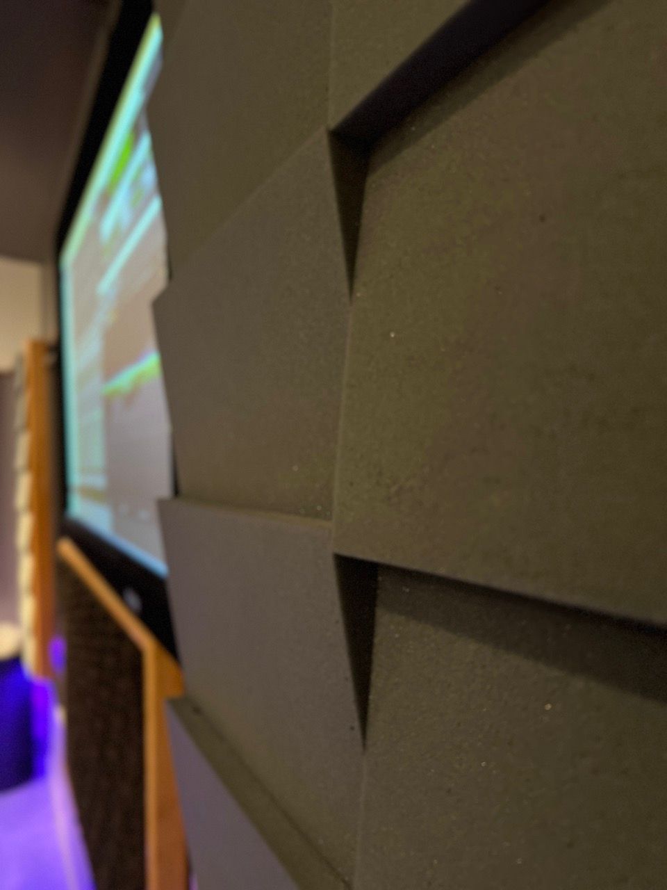 A projector screen is hanging on a wall in a room.