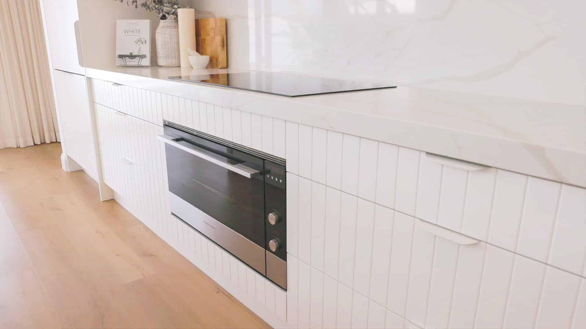 A Kitchen With White Cabinets and a Black Oven — Evolution Building Group Dapto, NSW