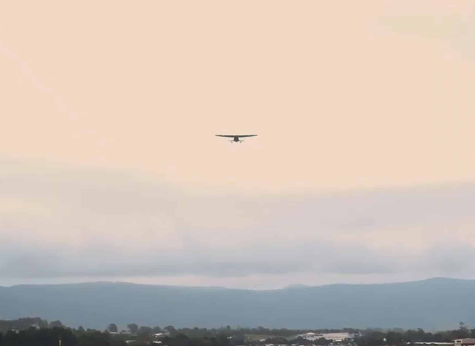 A Plane is Flying Through a Cloudy Sky Over a City — Evolution Building Group Dapto, NSW