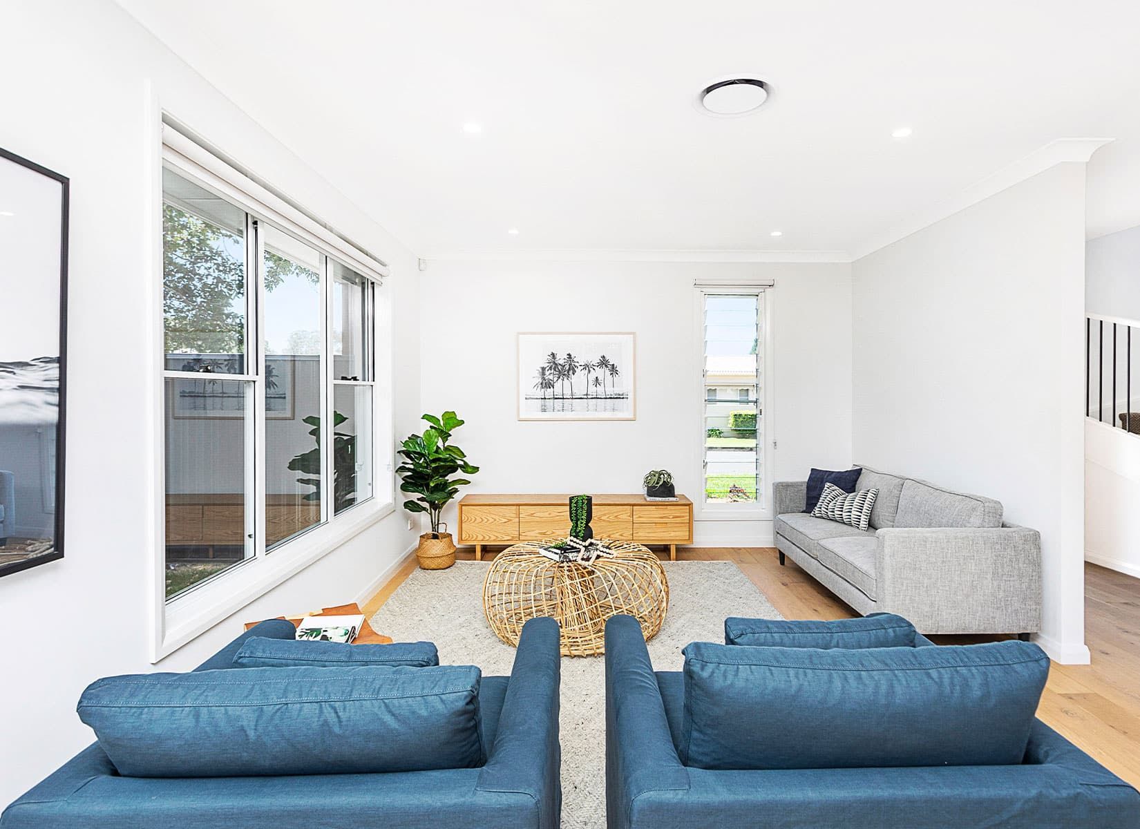 A Living Room With Blue Couches, Chairs, a Coffee Table and a Couch — Evolution Building Group Dapto, NSW