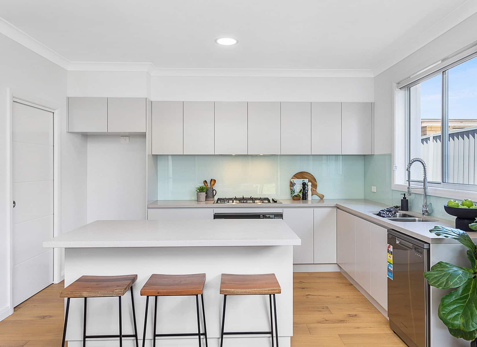 A Kitchen With White Cabinets and Wooden Floors — Evolution Building Group Dapto, NSW