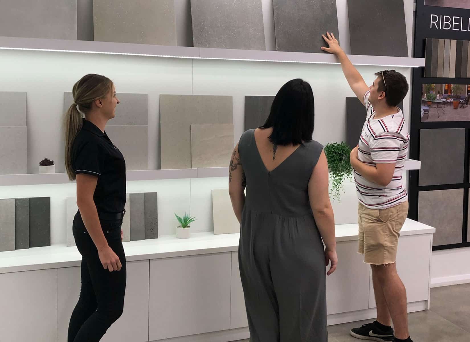 A Man and Two Women Are Looking at Tiles in a Store — Evolution Building Group Dapto, NSW