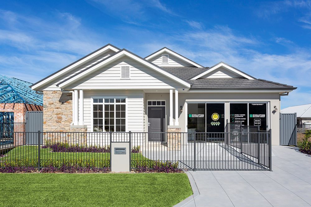 A Large White House With a Fence in Front of It — Evolution Building Group Dapto, NSW