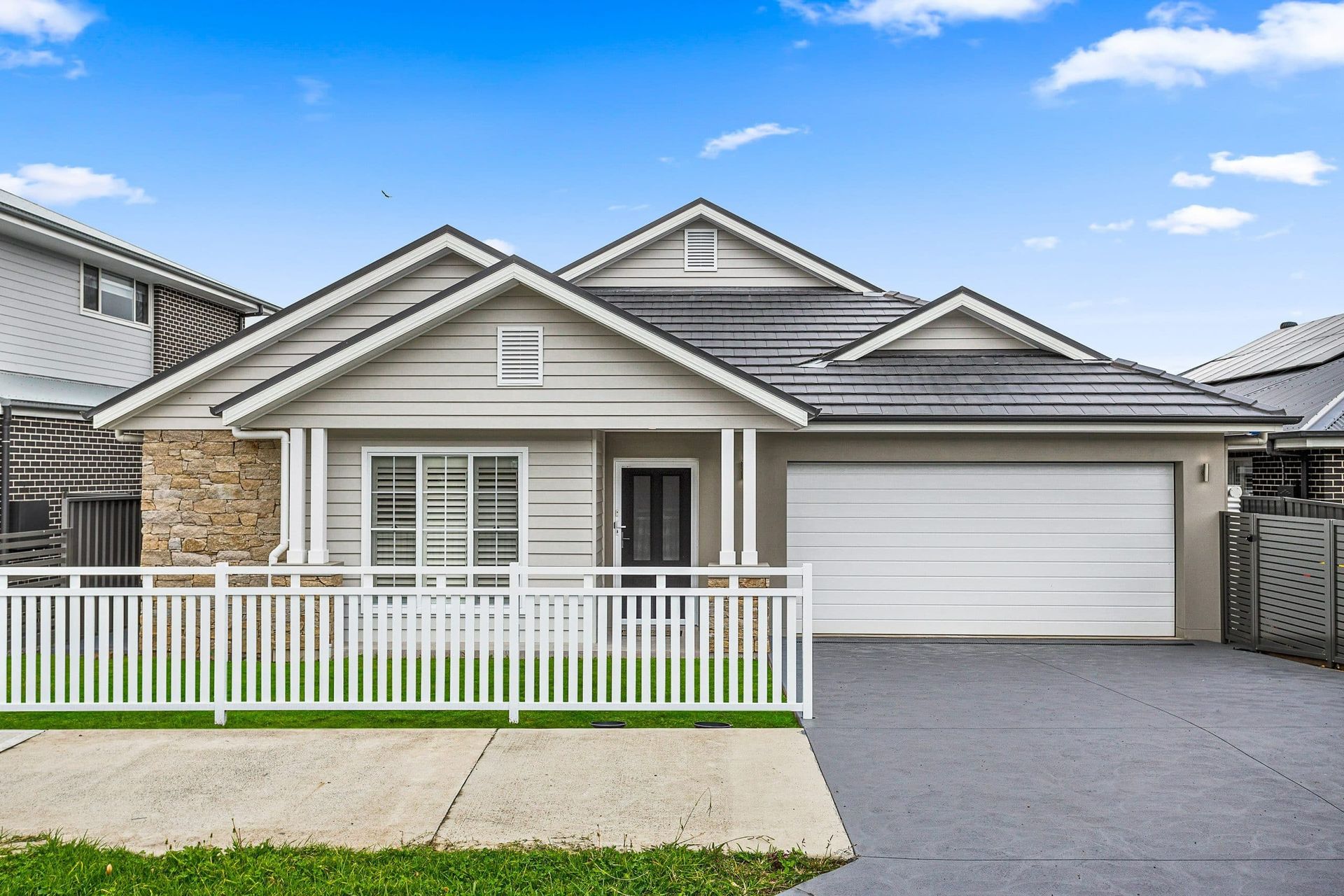 A House with A White Garage Door and A White Fence — Evolution Building Group Dapto, NSW