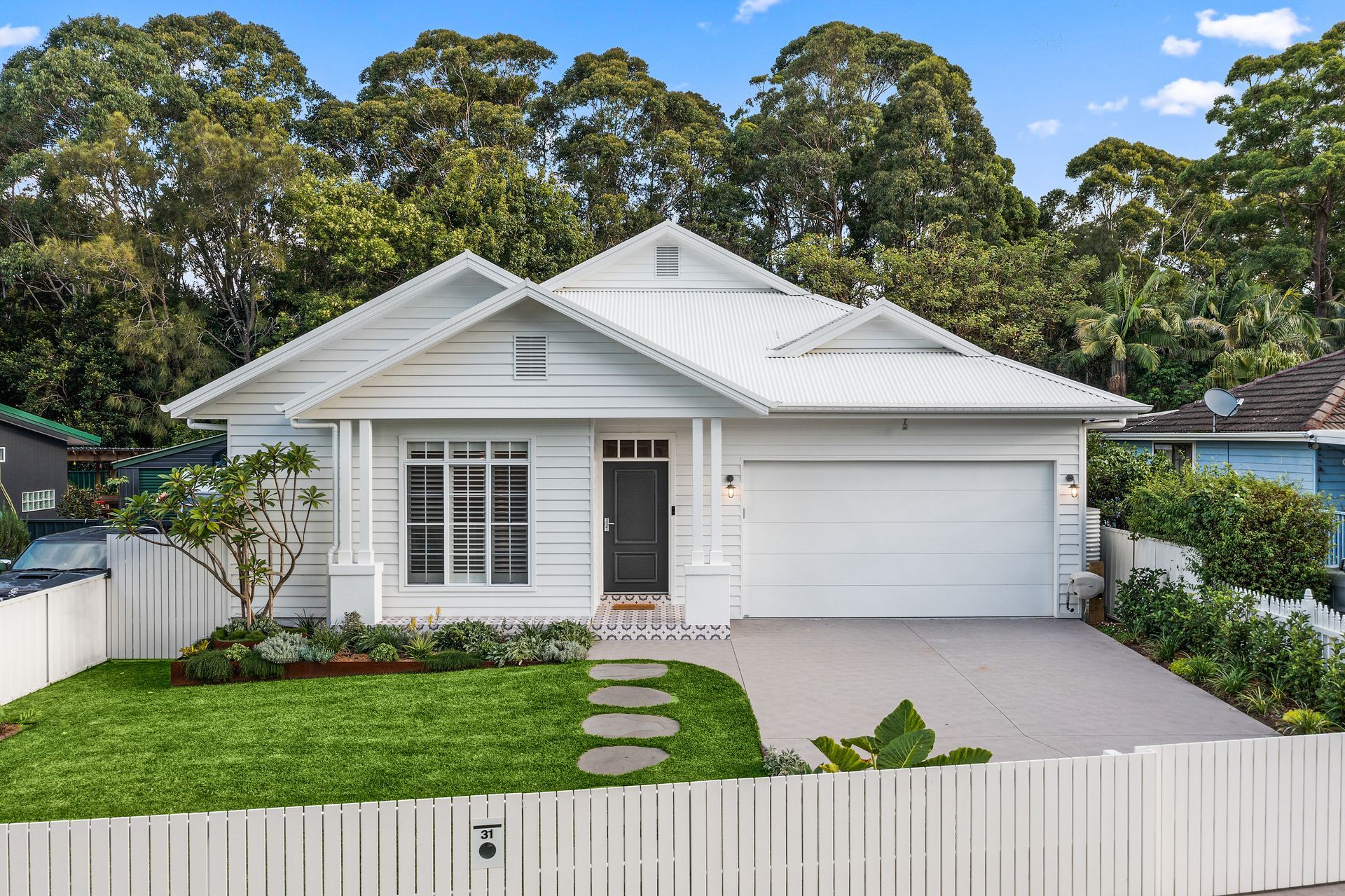 A Large Brick House with A Grey Garage Door — Evolution Building Group Dapto, NSW