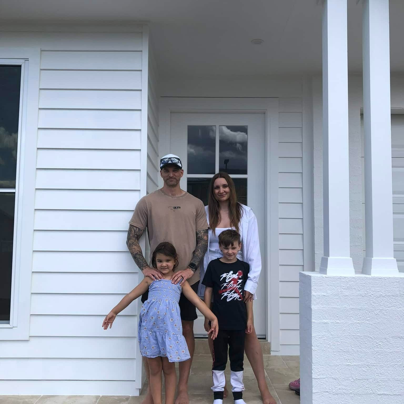 A Family Posing for a Picture in Front of a White House — Evolution Building Group Dapto, NSW