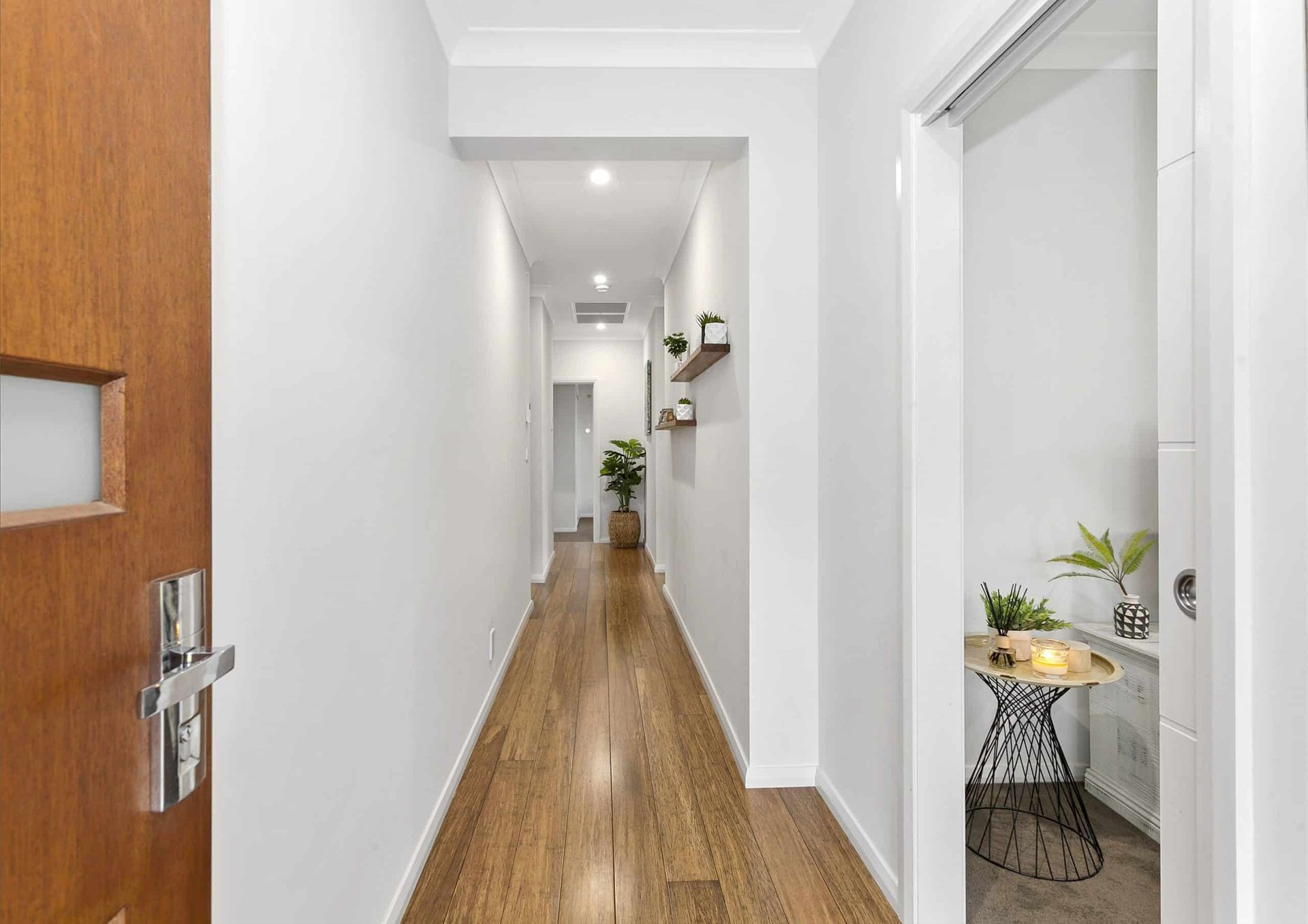 A Long Hallway With Wooden Floors and White Walls in a House — Evolution Building Group Dapto, NSW