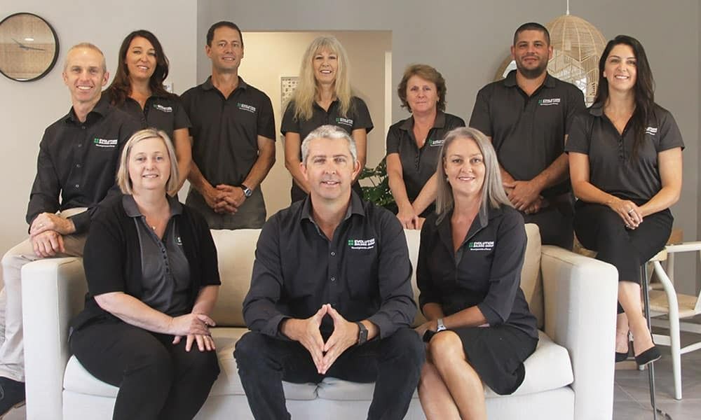 A Group of People Are Posing for a Picture While Sitting on a Couch — Evolution Building Group Dapto, NSW