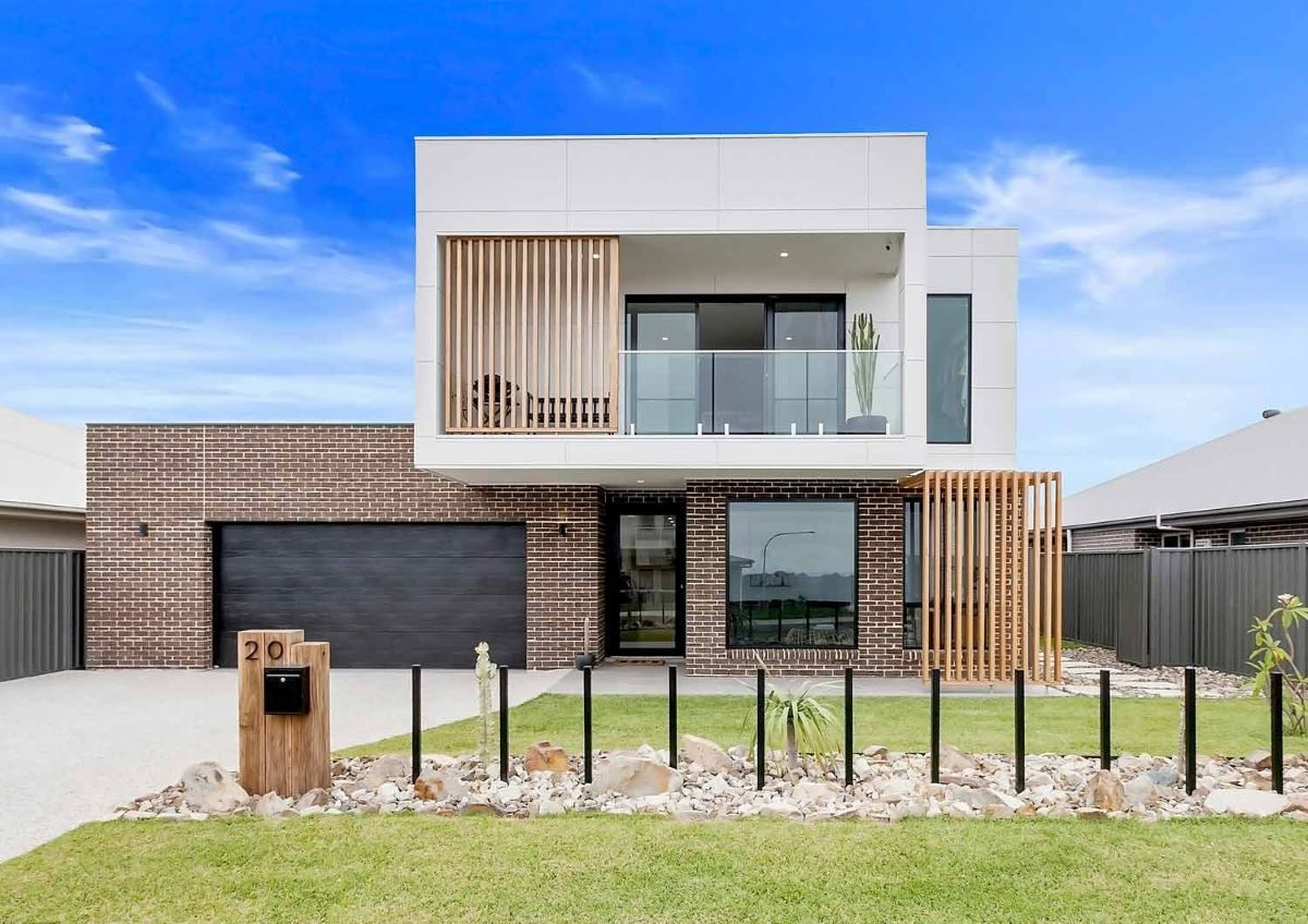 A Modern House with A Brick Facade and A Black Garage Door — Evolution Building Group Dapto, NSW