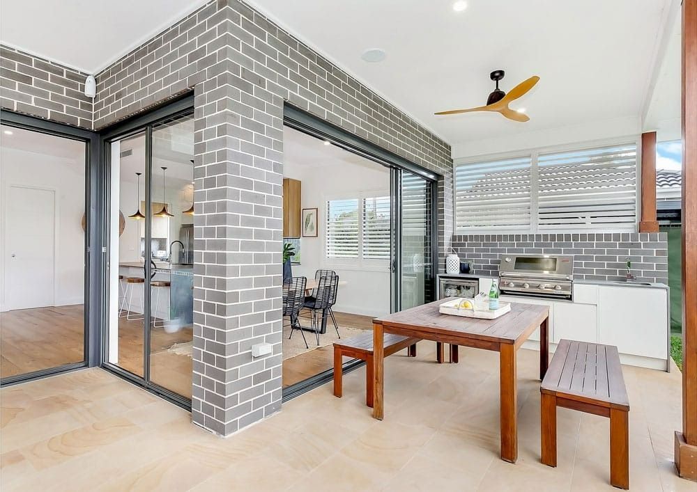 A Patio with A Table and Benches and A Ceiling Fan — Evolution Building Group In Shoalhaven, NSW