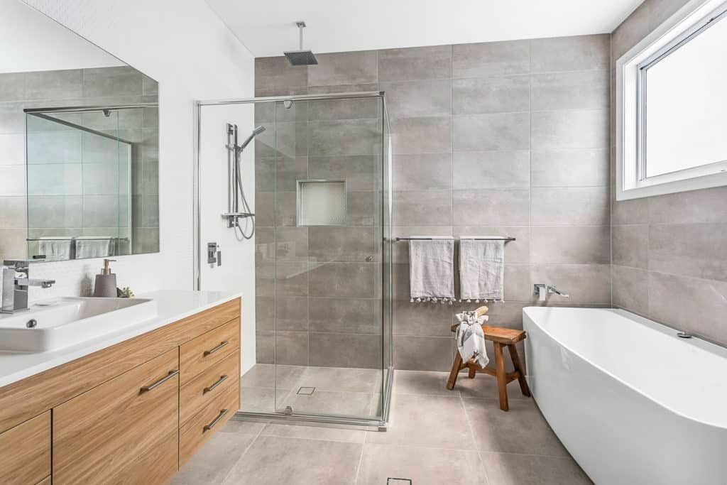 A Bathroom with A Tub, Sink, Shower and Mirror — Evolution Building Group In Nowra, NSW