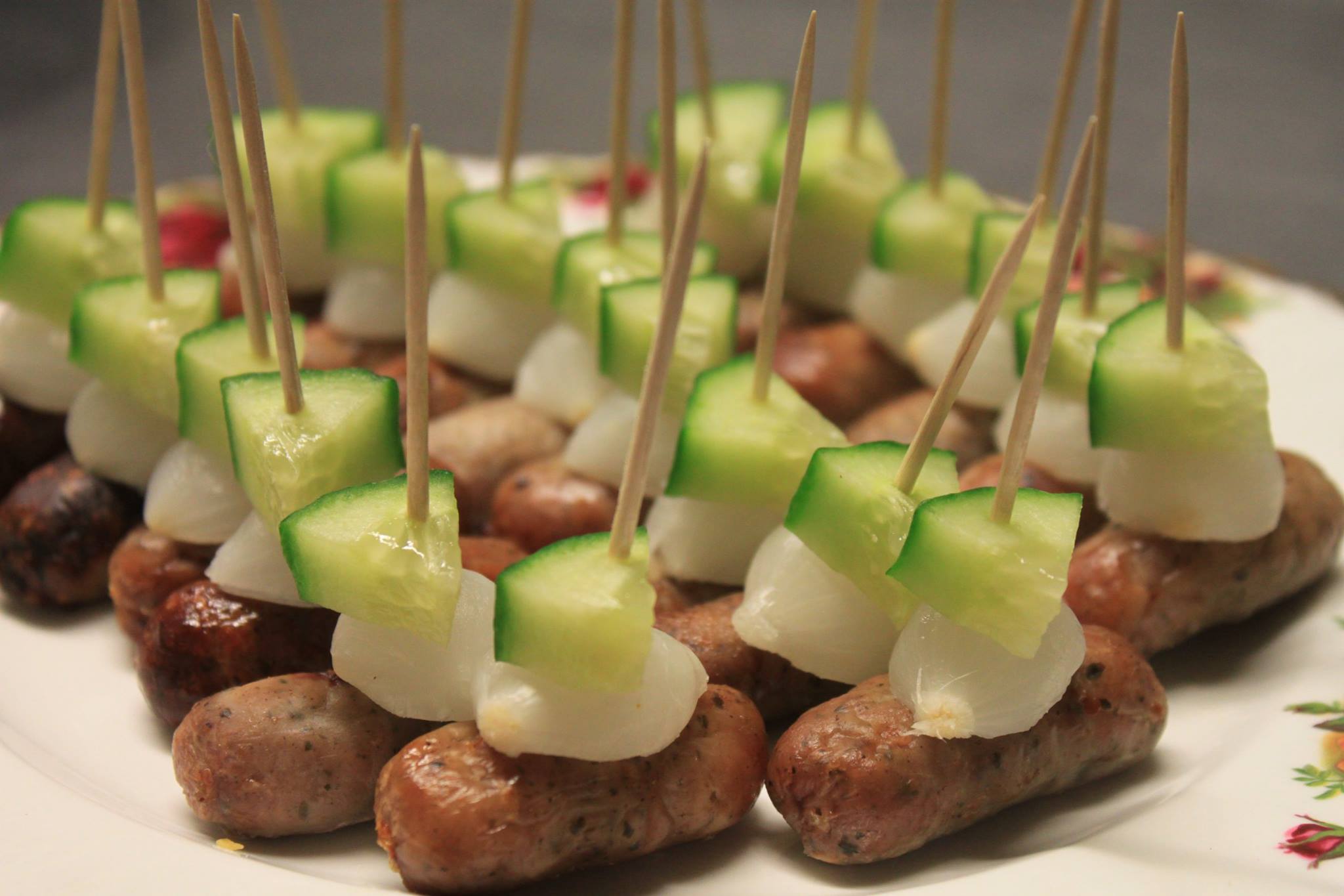 Cocktail sausages with pickle silverskin onions and cucumber on sticks.