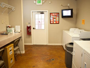 A laundry room with a washer and dryer and an exit sign