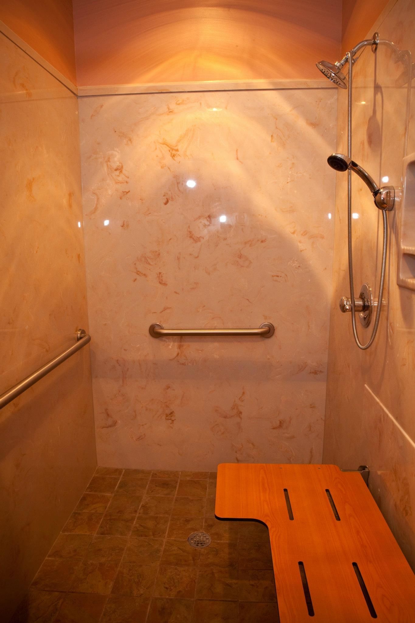 A bathroom with a walk in shower and a wooden bench.