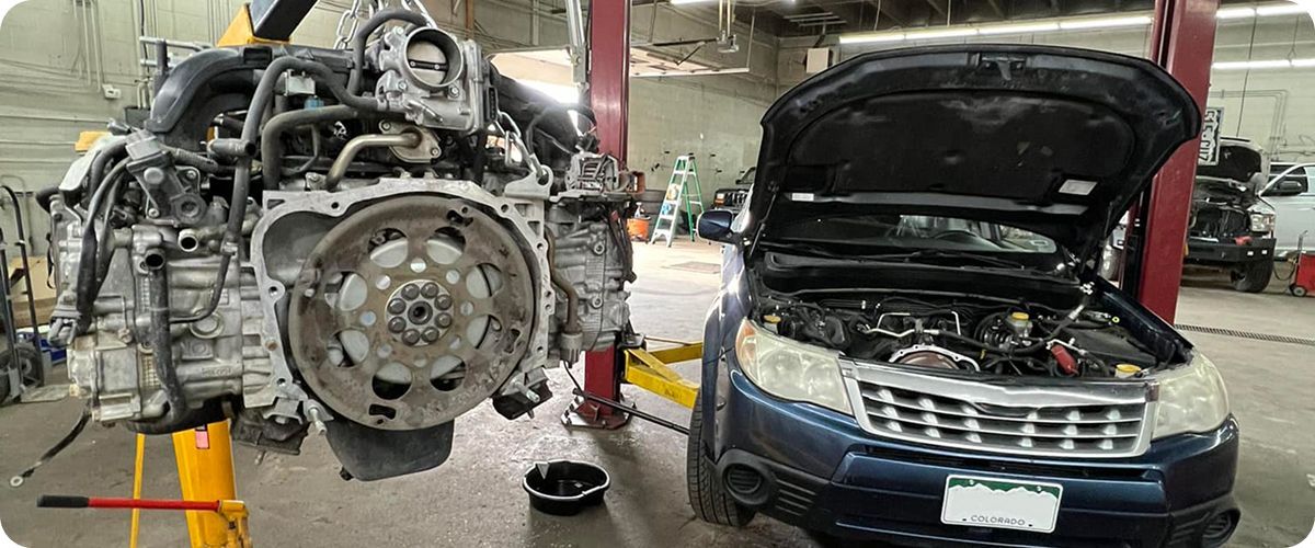 A car engine is being removed from a car in a garage. | Ridgeline Automotive