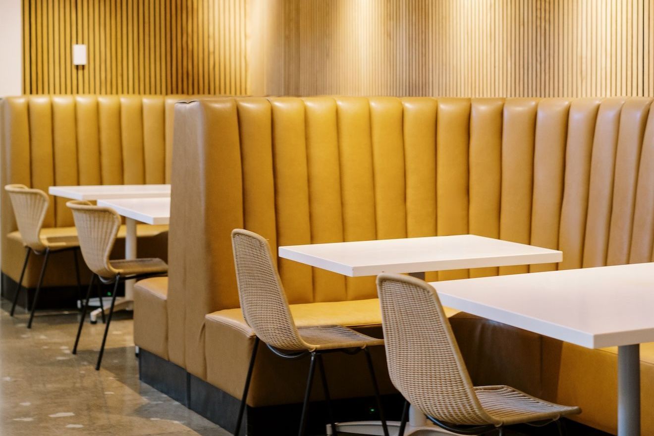 A row of tables and chairs in a restaurant.